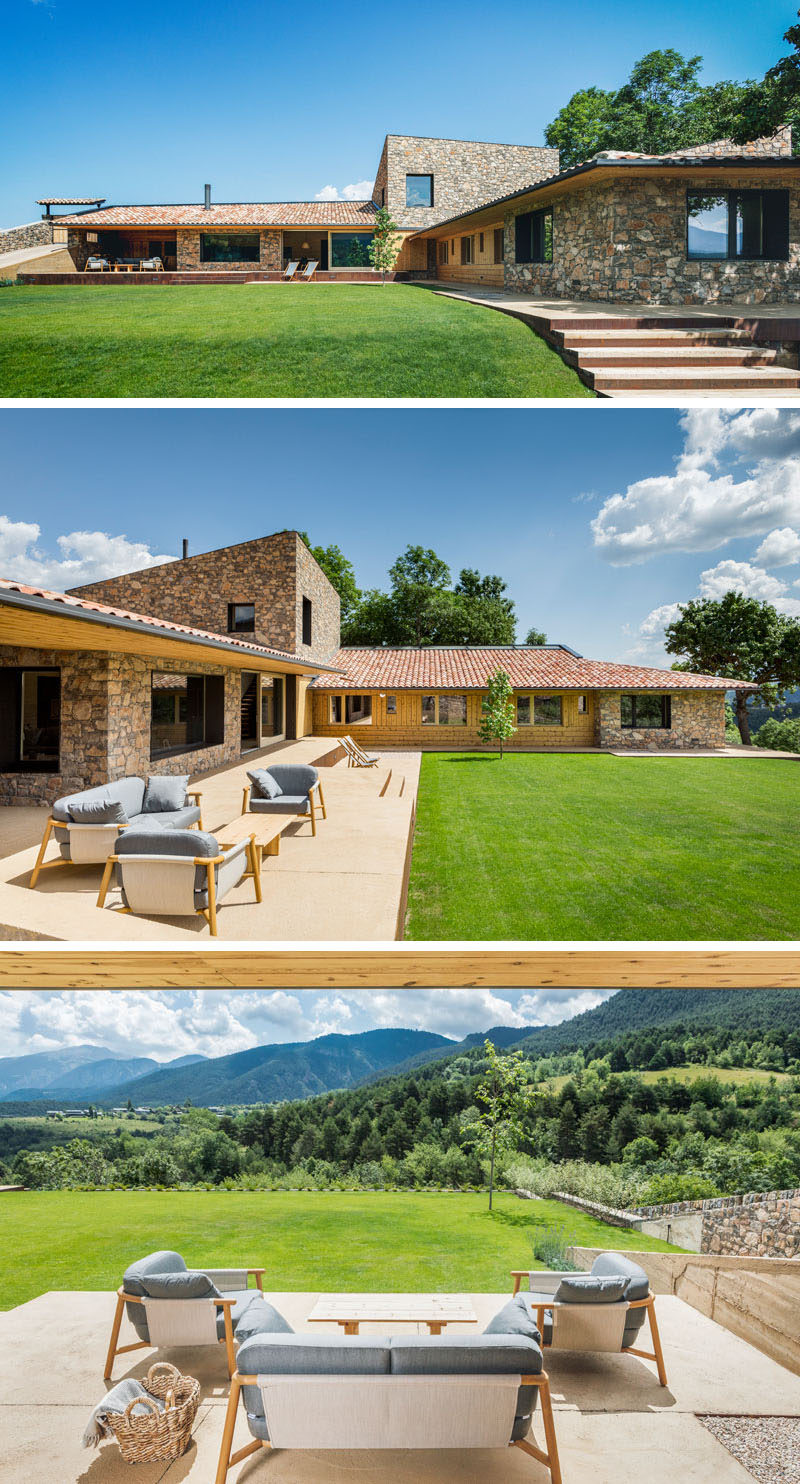 Sliding doors of this contemporary house, open to a porch with multiple levels and large grassy backyard, both of which enjoy views of the valley and the mountain of the Cadí-Moixeró Natural Park. #Landscaping #Porch #ContemporaryHouse #Stone