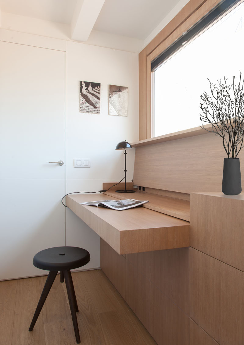 YLAB Arquitectos have hidden a desk in plain sight when they designed a small and modern apartment. The custom-made furniture piece has a hinged top, that when opened, can be used as a desk, and when more space is needed, a section of the cabinetry can be pulled out. #Desk #HiddenDesk #BuiltInDesk #InteriorDesign