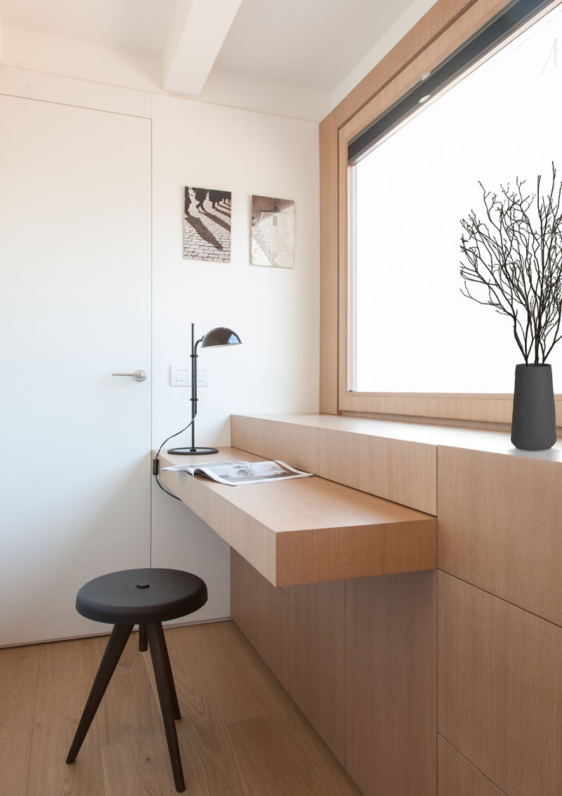 YLAB Arquitectos have hidden a desk in plain sight when they designed a small and modern apartment. The custom-made furniture piece has a hinged top, that when opened, can be used as a desk, and when more space is needed, a section of the cabinetry can be pulled out. #Desk #HiddenDesk #BuiltInDesk #InteriorDesign