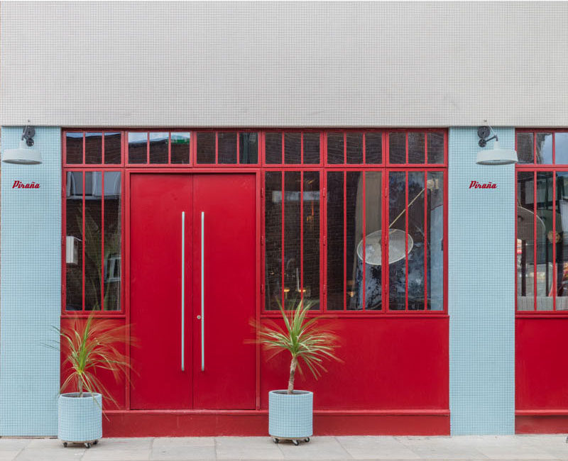 Sella Concept has recently completed the design and visual identity of Piraña, a South American-inspired bar and restaurant located in London, England. #RestaurantDesign #BarDesign #RedDoor