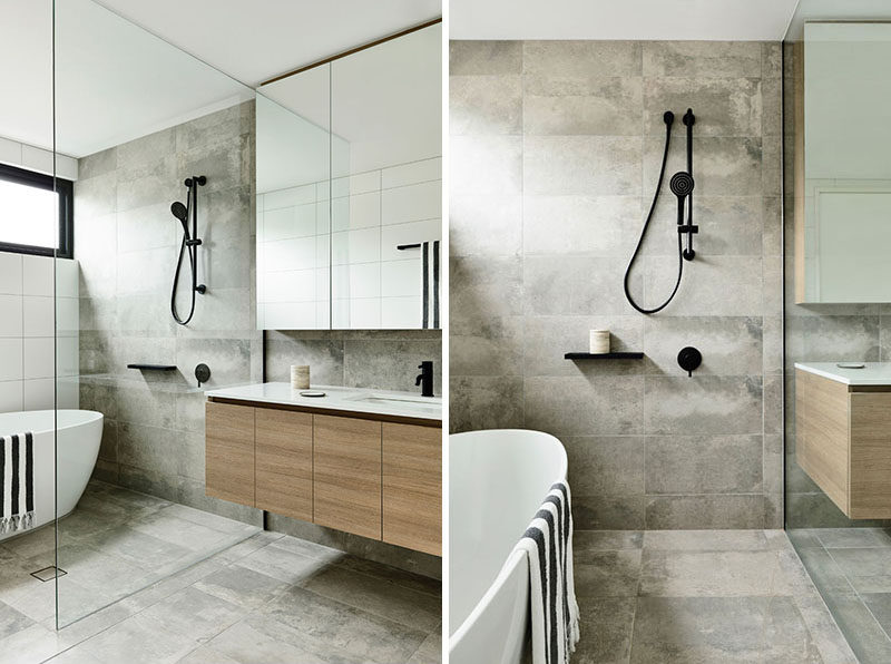 A glass partition separates the bath and shower from the dry areas of this bathroom, while allowing the natural light to filter through. #ModernBathroom #BathroomDesign