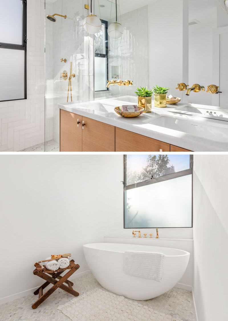 In this modern bathroom, a wood vanity with a marble top separates a freestanding bathtub from the walk-in shower. #ModernBathroom #BathroomDesign