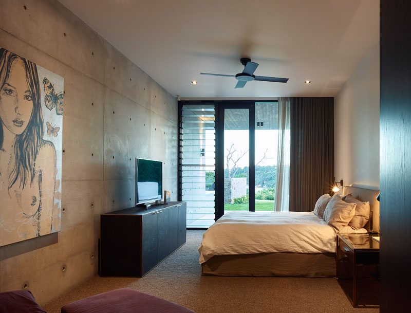 In this bedroom, a concrete wall has been paired with white smooth walls for a modern appearance. #ModernBedroom