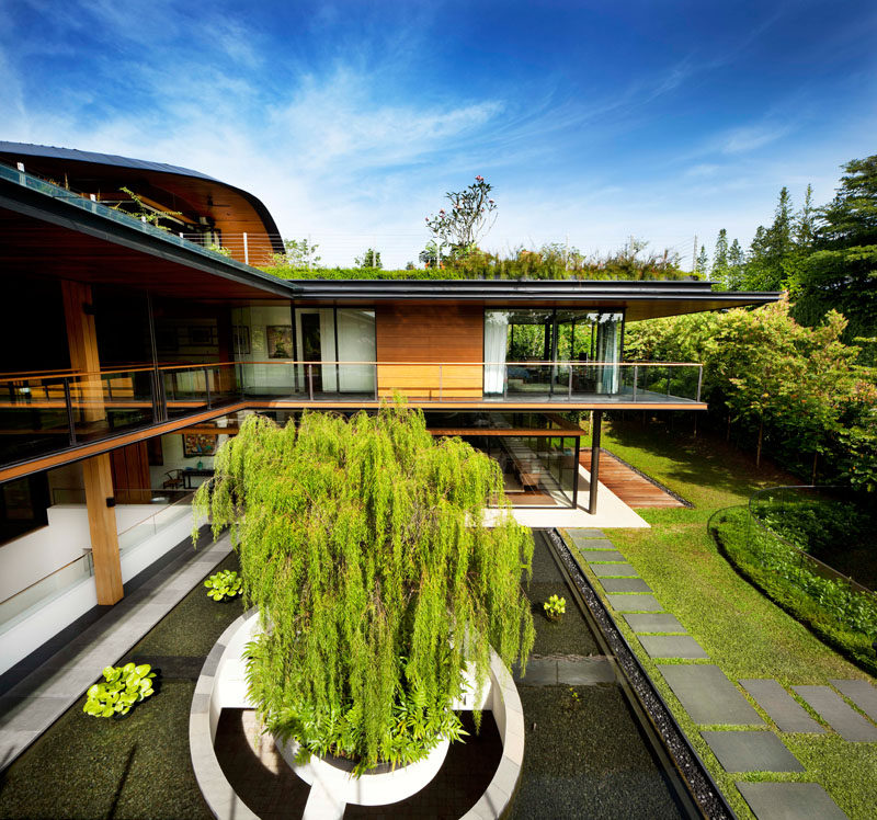 The architects designed this modern house in an L-shaped layout, allowing for the necessary privacy between two households, and at the same time providing a common courtyard and interconnected social spaces. #ModernHouse #Landscaping #Architecture #WaterFeature