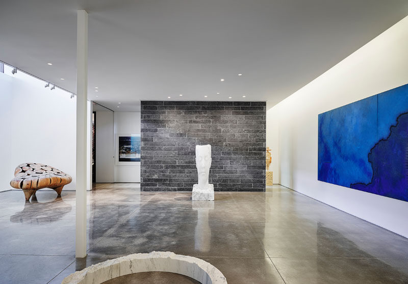 This modern home features a sub-grade gallery space that houses paintings, photography, and sculpture, spanning 20 years of collecting, with specific lighting and climate control for the preservation and display of such works. #ModernHouse #PersonalArtGallery #ArtGallery