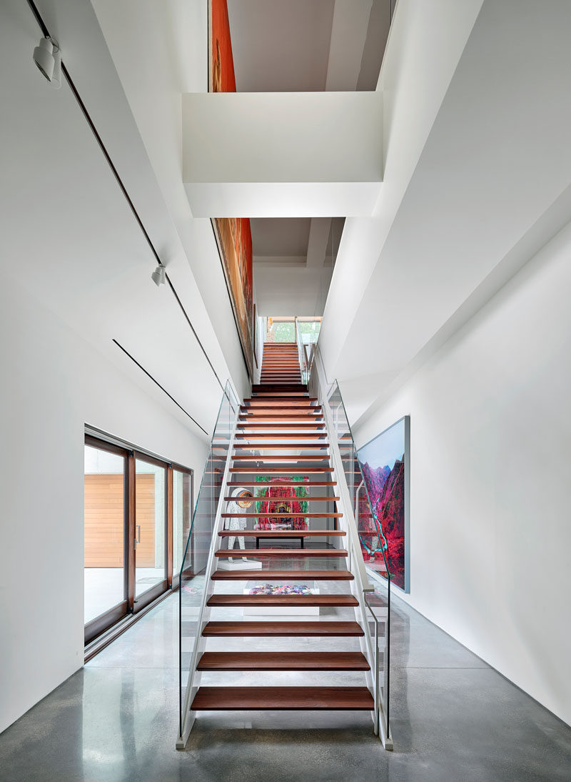 Double-height atriums connect the gallery and living spaces of this modern house, and these art-laden circulation paths become the “arteries” that bestowed the residence’s name. #Stairs #Atrium #ModernStairs