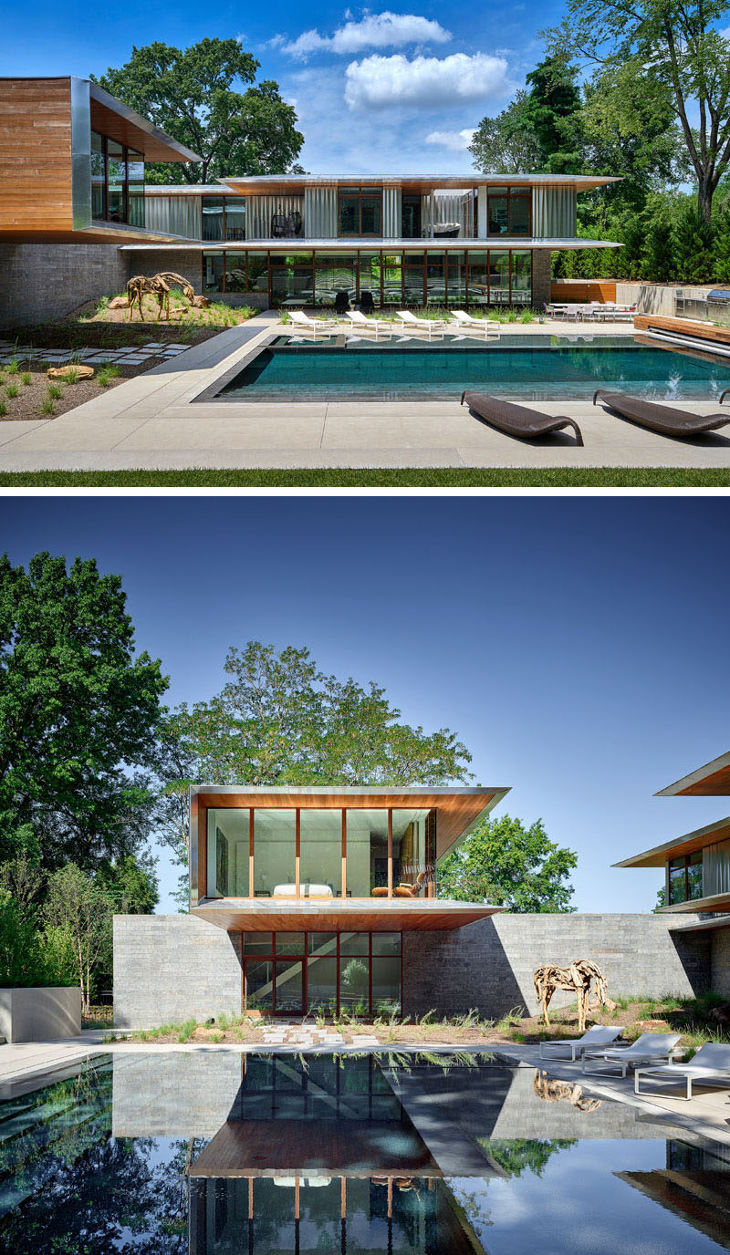 This modern house opens up to the backyard that has a swimming pool and outdoor kitchen. From this angle, you can also see the cantilevered guest suite, that's clad in cedar and aluminum. #ModernHouse #SwimmingPool #Cantilever