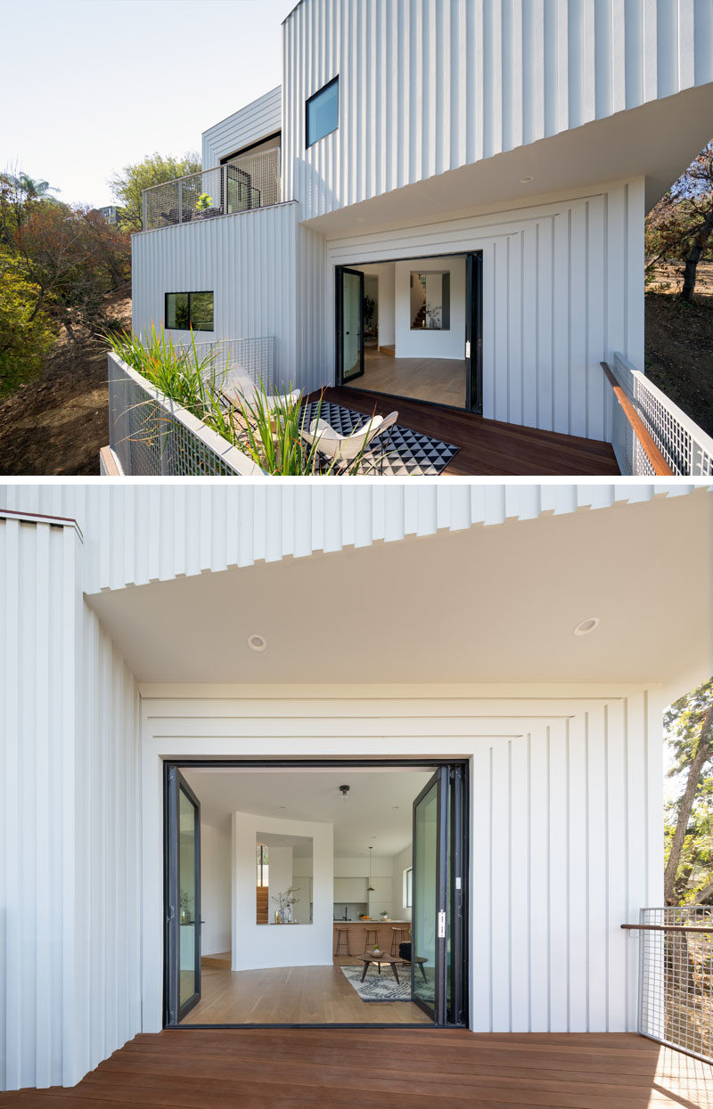 This modern four storey house has the primary living spaces (dining, kitchen, living room, and den) located on the third level. #ModernHouse #WhiteSiding #Architecture