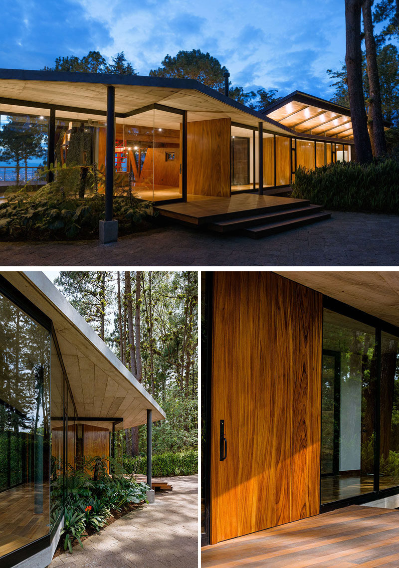 A large pivoting wood door welcomes visitors to this modern house. #FrontDoor #WoodFrontDoor #PivotingFrontDoor