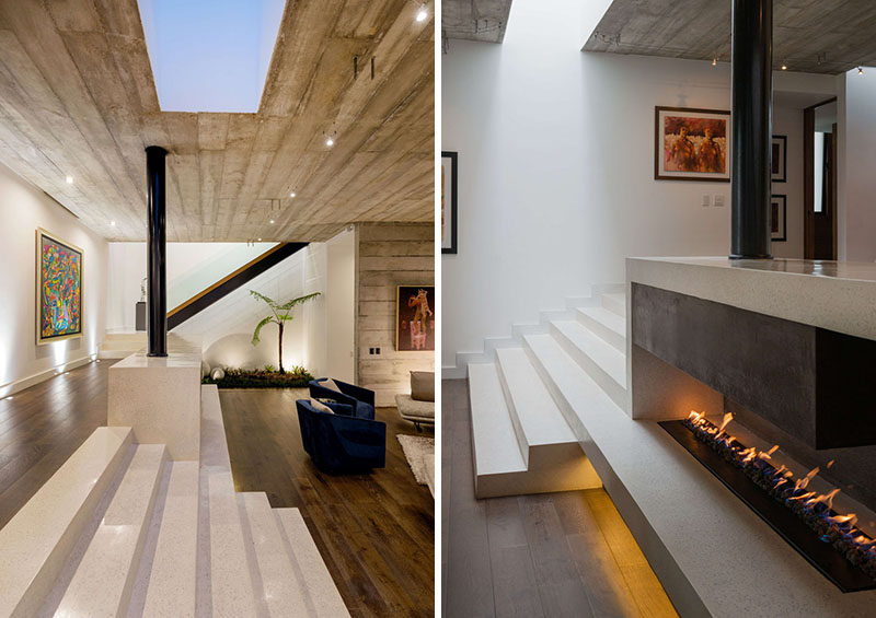 Steps, made from concrete poured in place, lead down to the living room of this modern house, that features a fireplace, whose hearth is integrated into the steps. #Fireplace #Steps #ModernHouse