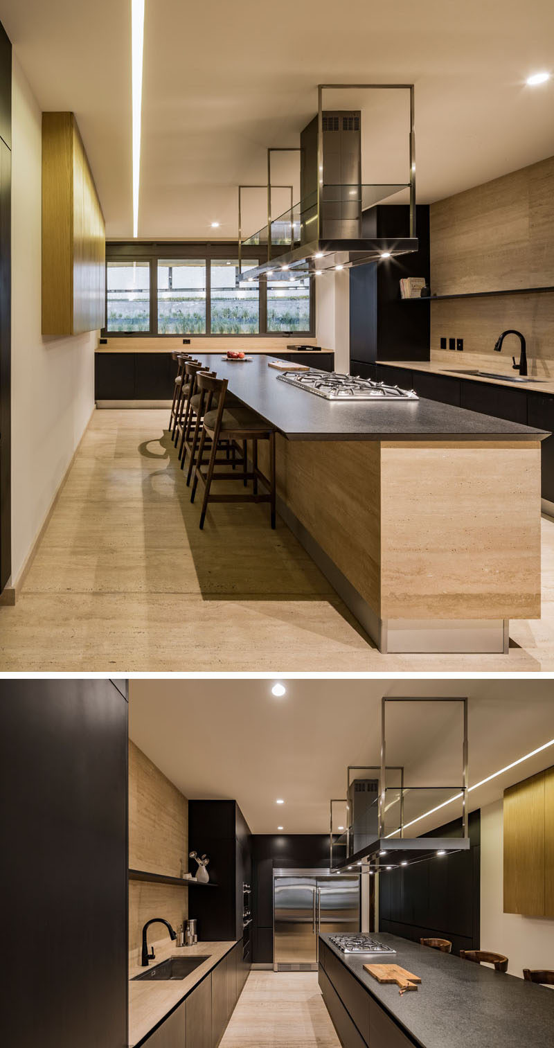 A large island is central to this modern kitchen, and the overhang provides a place for people to sit at. #KitchenDesign #LargeKitchenIsland #ModernKitchen