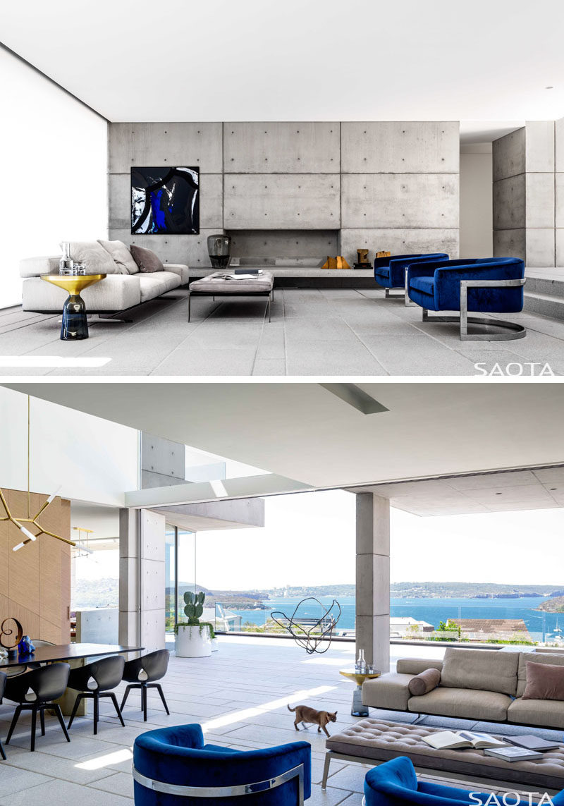 In this modern living room, neutral colors have been combined with pops of blue succeeded to create a sophisticated feeling within the home. #ModernLivingRoom #ConcreteWall #OpenPlanInterior