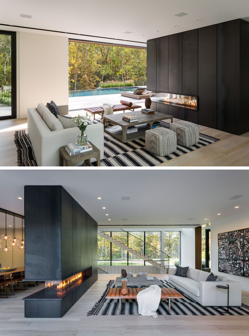 In this modern living room, the furniture is positioned to take advantage of the backyard view and the three-sided fireplace that's clad in blackened steel. #ModernLivingRoom #BlackSteelFireplace #Fireplace