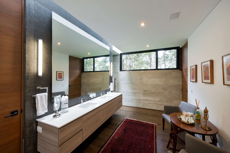 In this contemporary master bathroom, a large mirror helps to reflect the light from the window. #BathroomDesign #ContemporaryBathroom