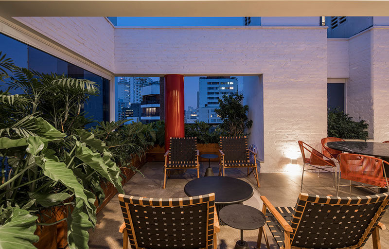 This modern apartment terrace features white bricks, concrete, wood, stone, and plenty of plants. A variety of seating areas create an outdoor living space, extending the usable space of the apartment. #ModernTerrace #ApartmentTerrace