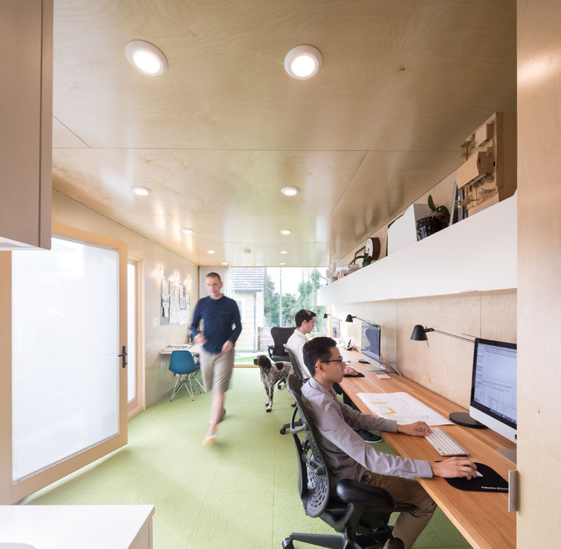 The interior of of this modern shipping container office office is lined in birch plywood to create a sense of warmth, and the Douglas Fir desk, which runs along one wall, spans 19 feet, providing a flexible working space. #ShippingContainerOffice #HomeOffice #InteriorDesign #Workplace