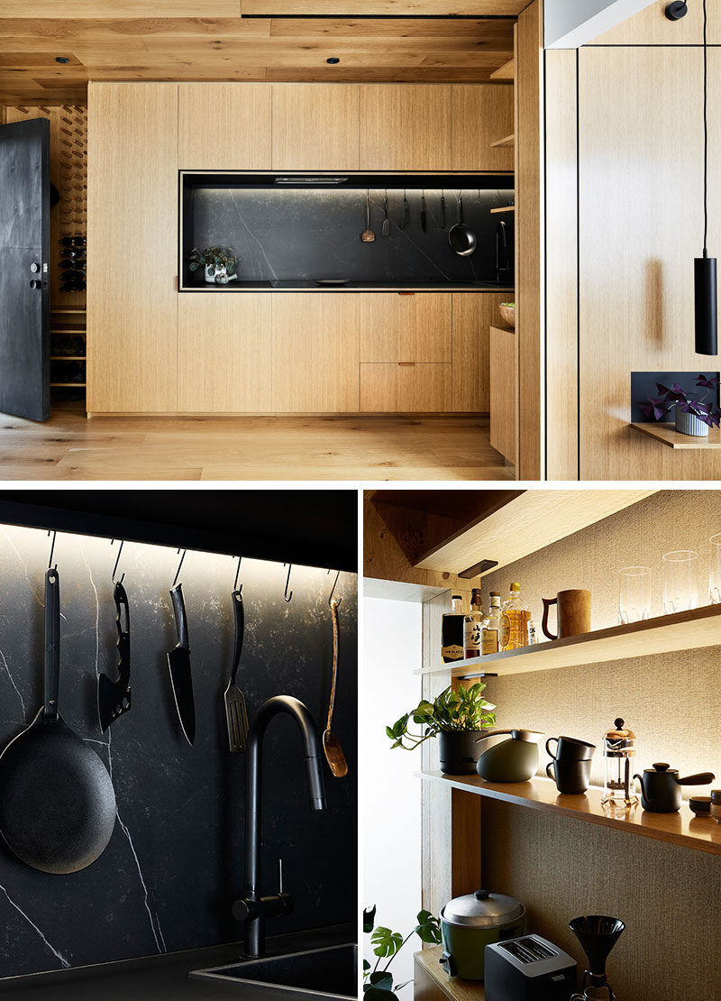 This modern and small kitchen, surrounded by wood, is 13 feet long, with the fridge and a washing machine hidden within the kitchen cupboards. Black has been used to contrast the wood, from the matte black countertop, to black sink and taps, and kitchen utensils. #WoodKitchen #WoodAndBlackKitchen #ModernKitchen #KitchenDesign