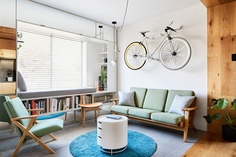 In this small apartment, the living room features a built-in window seat with shelving and enclosed storage. #LivingRoom #WindowSeat #SmallApartment