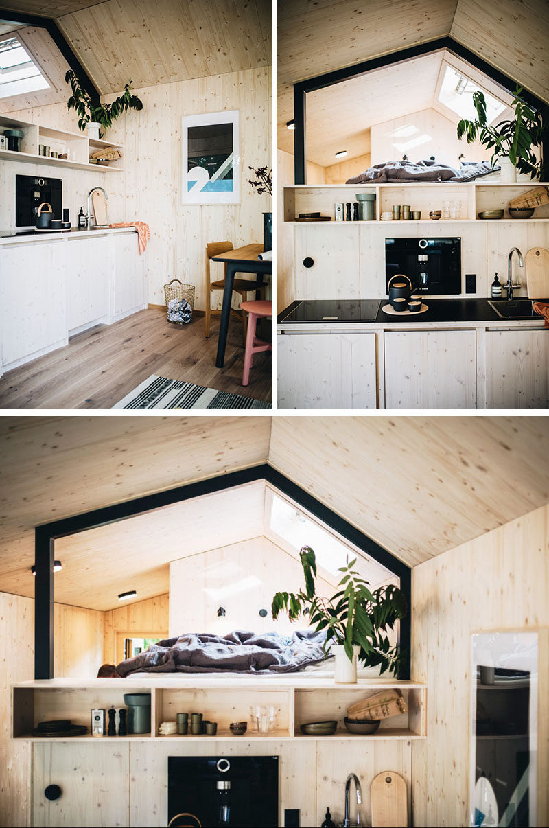 In the small kitchenette of this tiny home, there's a regular size cooktop and a sink, while a fridge and washing machine are hidden within the cabinets below. #TinyHome #UrbanCabin #Kitchenette #Kitchen #LoftBed