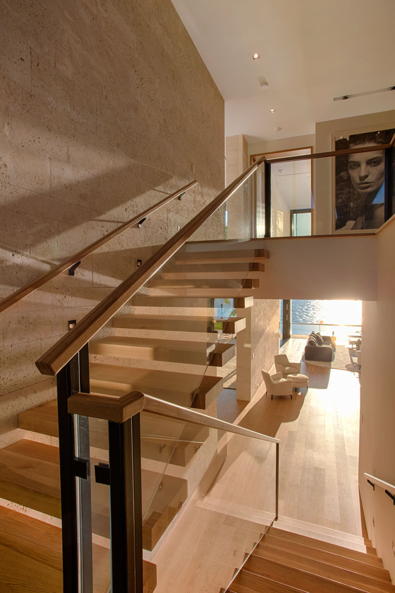 Wood stairs with glass railings connect the various levels of this modern house. #Stairs #ModernStairs