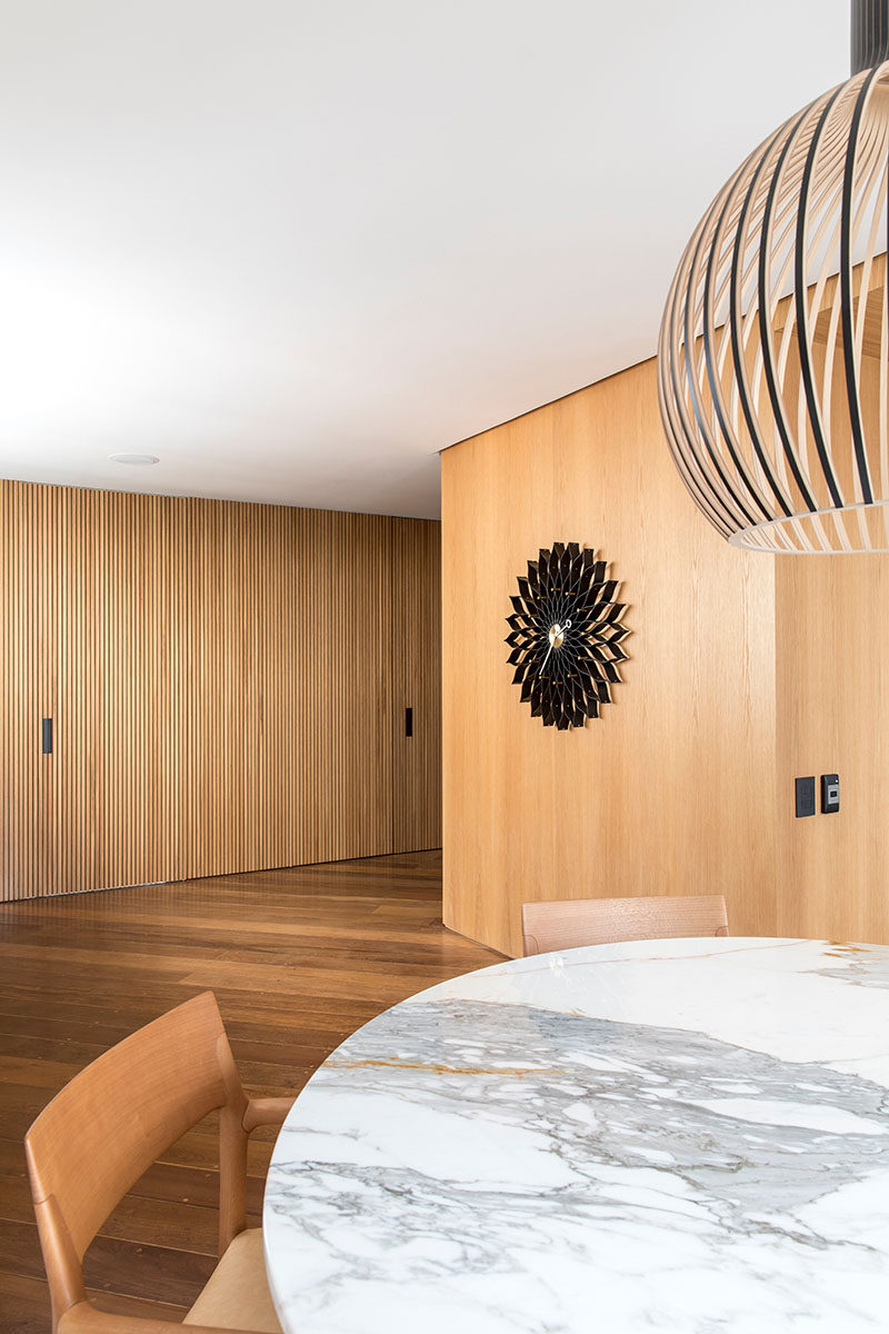 The wood slat wall in this room hides doors to a bathroom and storage room. #WoodSlatWall #InteriorDesign