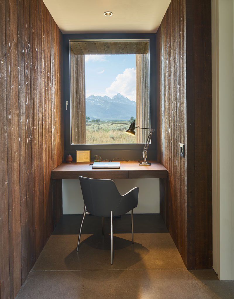 A custom-built office desk is sandwiched between the different pavilions of this modern house, with a window that makes the view beyond almost appear as a piece of framed artwork. #HomeOffice #Desk #Windows #InteriorDesign