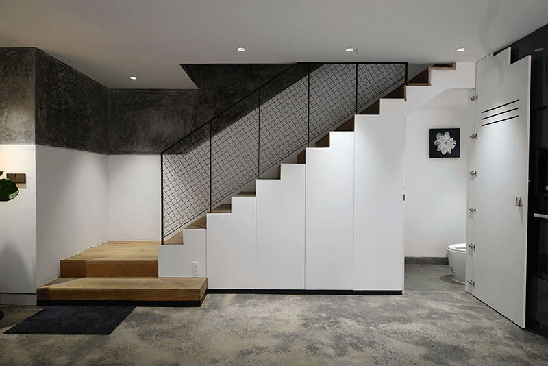 These modern stairs have storage and a small powder room hidden underneath them. #Stairs #StairsWithStorage #PowderRoom