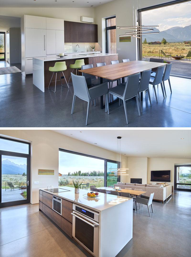 The kitchen cabinet doors and the dining table have been created from a mixture of walnut, mimicking the same hue as the Douglas Fir featured on the exterior of the house. #ModernKitchen #WhiteAndWoodKitchen #WoodDiningTable