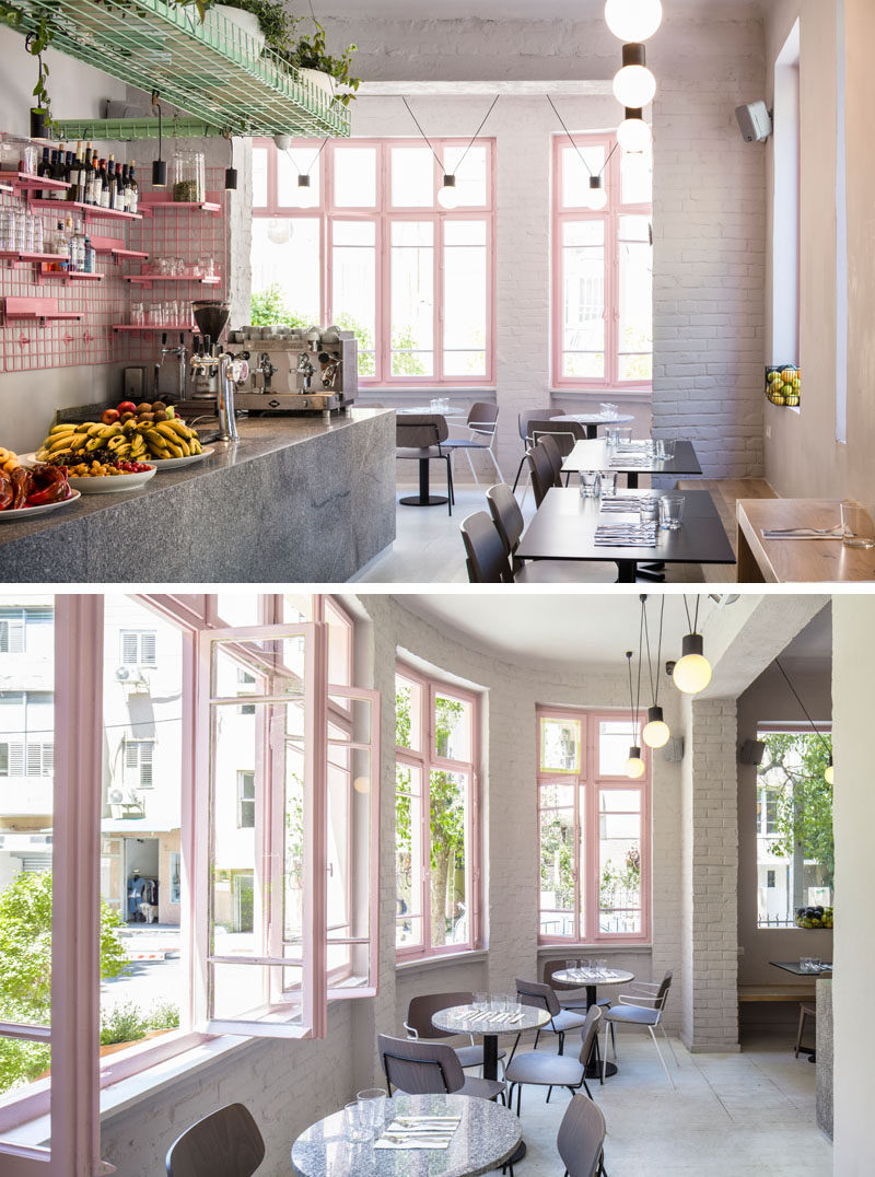 The high ceilings and wood-framed windows of this modern cafe create a feeling of openness, while the original brick walls have been painted in light grey. #CafeDesign #ModernCafe #InteriorDesign