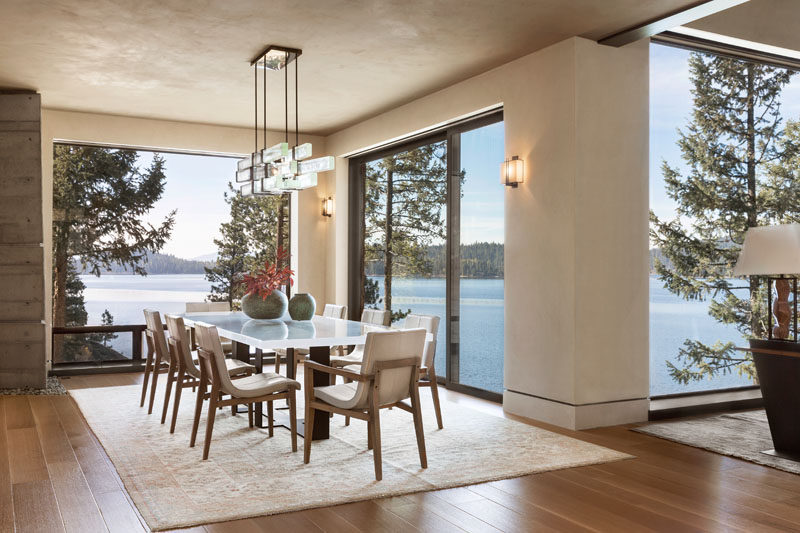 The walls throughout the house, like in the dining room, have been finished with plaster to create a soft, mottled finish in contrast to the sharp lines of steel that punctuate the architecture. #DiningRoom #ModernDiningRoom