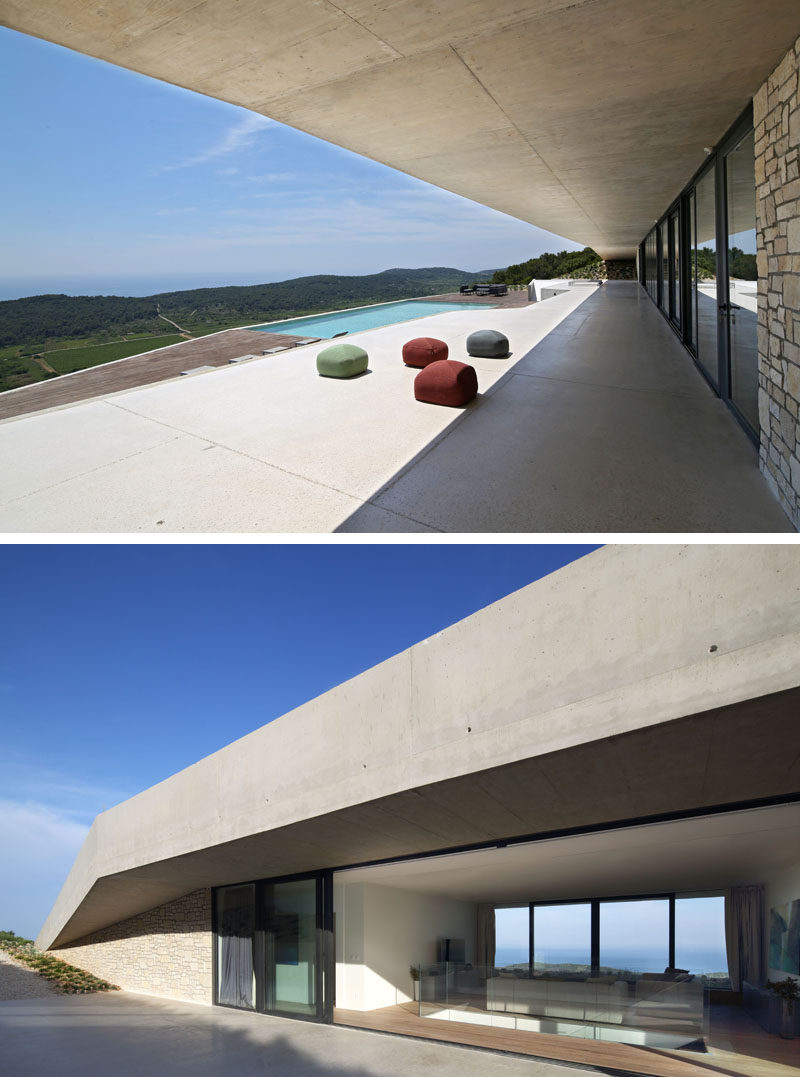 A large overhang provides shade and shelter for the interior of this modern concrete house. #ConcreteHouse #ModernArchitecture