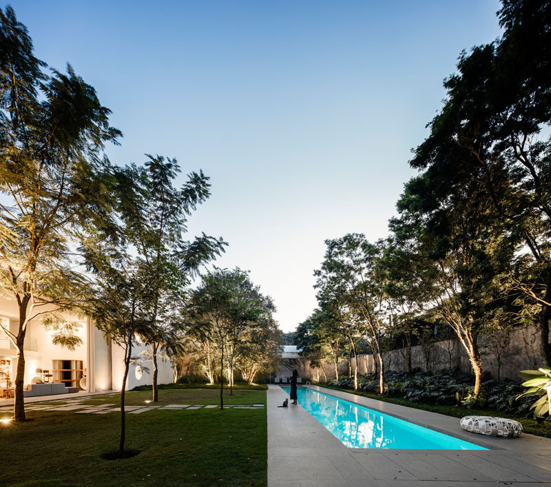 The living room of this modern house opens to a landscaped backyard with a 9 x 98 foot (3 x 30m) swimming pool. #ModernLandscaping #SwimmingPool