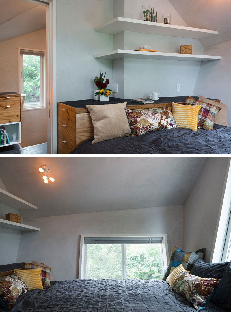 In this small bedroom, the bed has been built into the room, with wood cabinetry doubling as a headboard. Windows on two walls help to keep the space feeling open. #SmallBedroom #BuiltInBed #Shelving