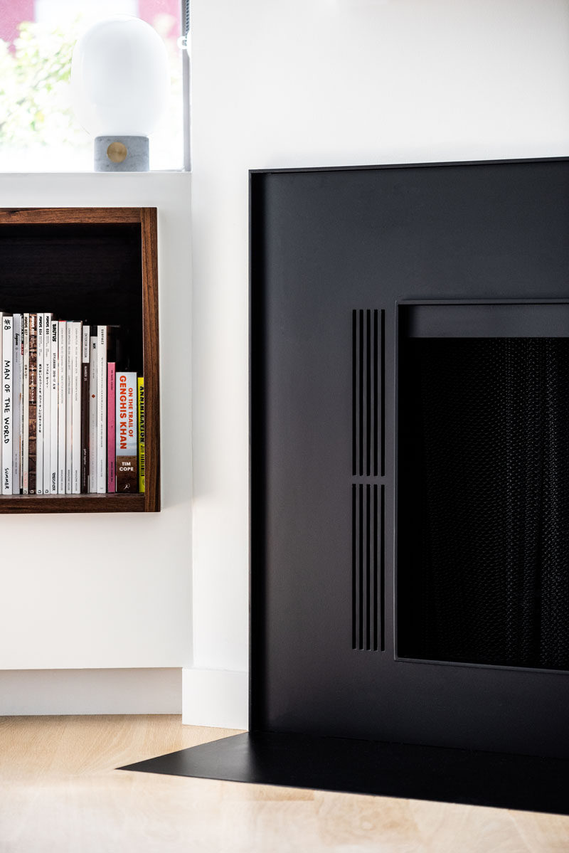 As part of a modern residential interior renovation, architect and interior design firm OFFICIAL, included a wood-lined built-in window seat and bookshelf in the master bedroom. #WindowSeat #Bookshelf #Fireplace