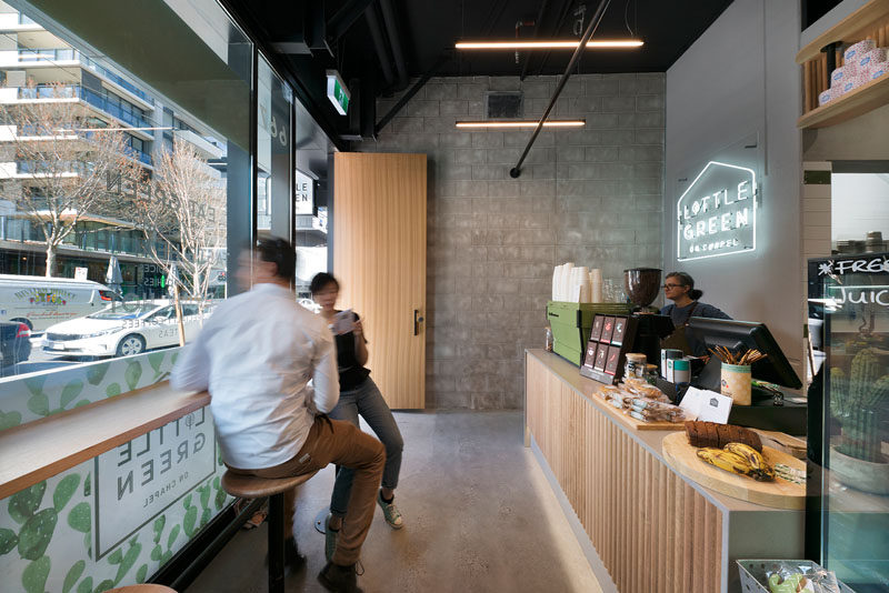 In this small and modern cafe, bar seating along the window provides a place for people to wait for their food while viewing the street. #CafeDesign #InteriorDesign