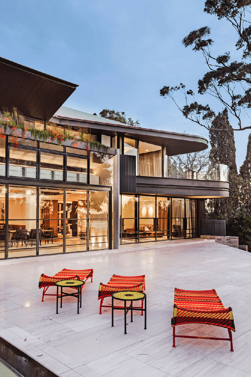 This modern house opens up to a large backyard, with a terrace connecting the house to the swimming pool and cabana. #ModernHouse #HouseDesign #Landscaping