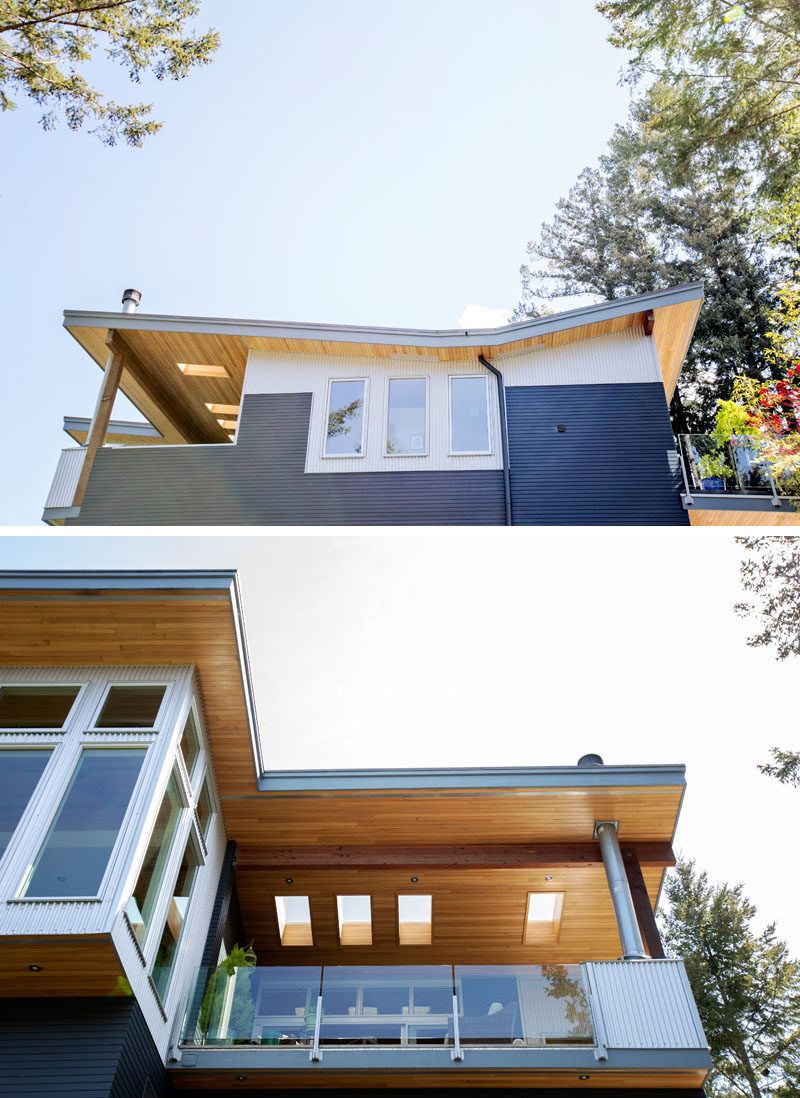 This modern multi-storey house features a butterfly roof, huge overhangs, clear hemlock soffits and ceilings that continue from inside to outside, wood cladding in a deep navy colour, and vertical galvanized corrugated steel siding. #ModernHouse #Architecture #ButterflyRoof
