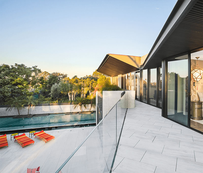 The bedrooms located on the upper floor of this modern house, open to a balcony that has a view of the backyard and swimming pool. #Balcony #ModernHouse