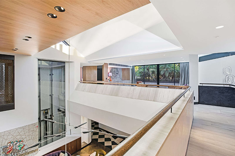This modern house has a central double volume atrium, that overlooks the living room below and is lit by upper-level skylights. #ModernHouseDesign #Atrium