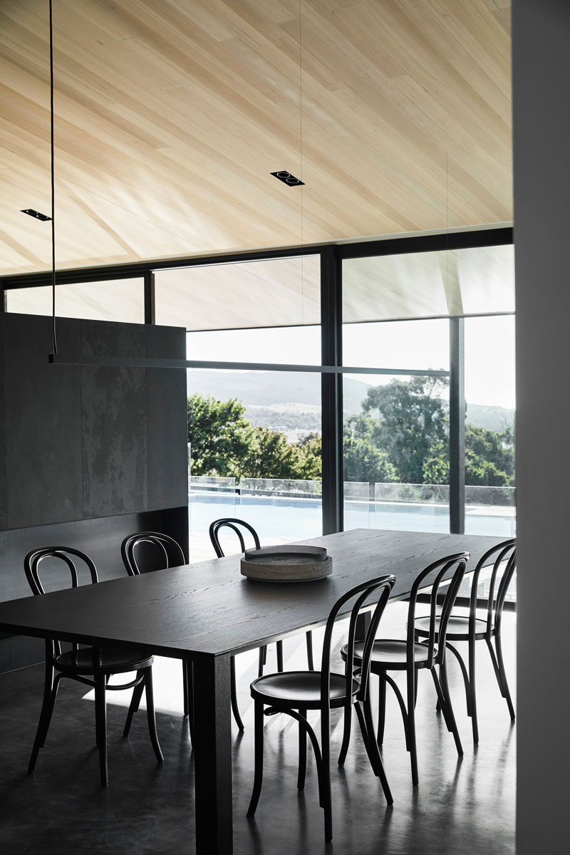 This modern farm house features light oak wood ceilings and large windows that show off the views and the swimming pool from the dining room. #WoodCeiling #DiningRoom