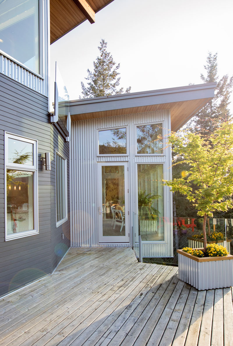 This modern house uses dark blue horizontal siding and silver corrugated vertical siding. #ModernHouse #HouseSiding