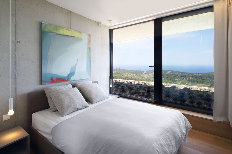 This bedroom has large windows that take advantage of the water views, and provide a glimpse of the green roof. #BedroomDesign #Windows