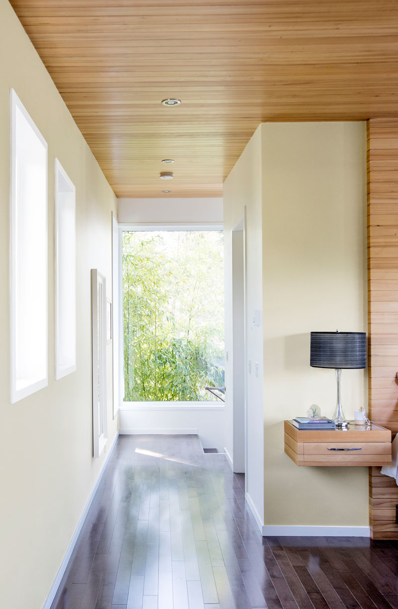 This modern house uses dark wood flooring to contrast the lighting wood used on the ceiling. #DarkWoodFlooring #LightWoodCeiling