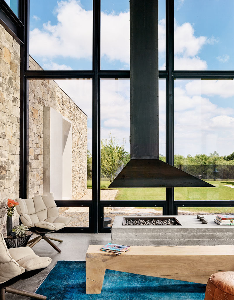 This modern house has large black framed windows that match the black steel fireplace flue. #Fireplace #SteelFireplace #Windows