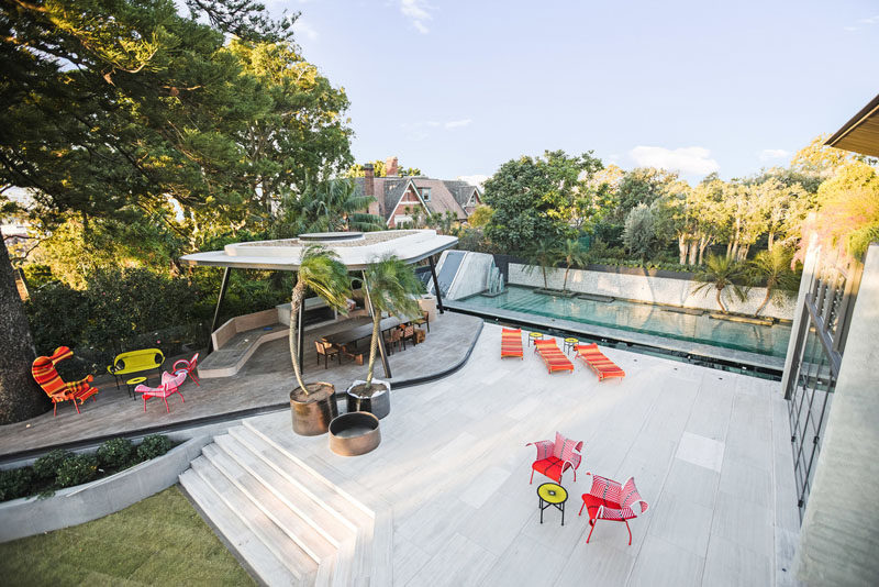 This modern backyard has a large terrace, and a freeform concrete and steel cabana that sits next to a large pool with a 17m glass-bottomed pond feature. #Backyard #Landscaping #Pool #Cabana