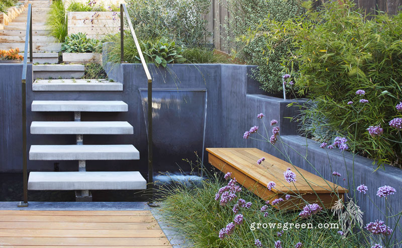 This backyard was transformed into a modern tiered garden with seating, a firebowl, a water feature, and stairs connecting the different levels. #ModernBackyard #ModernLandscaping #TieredBackyard