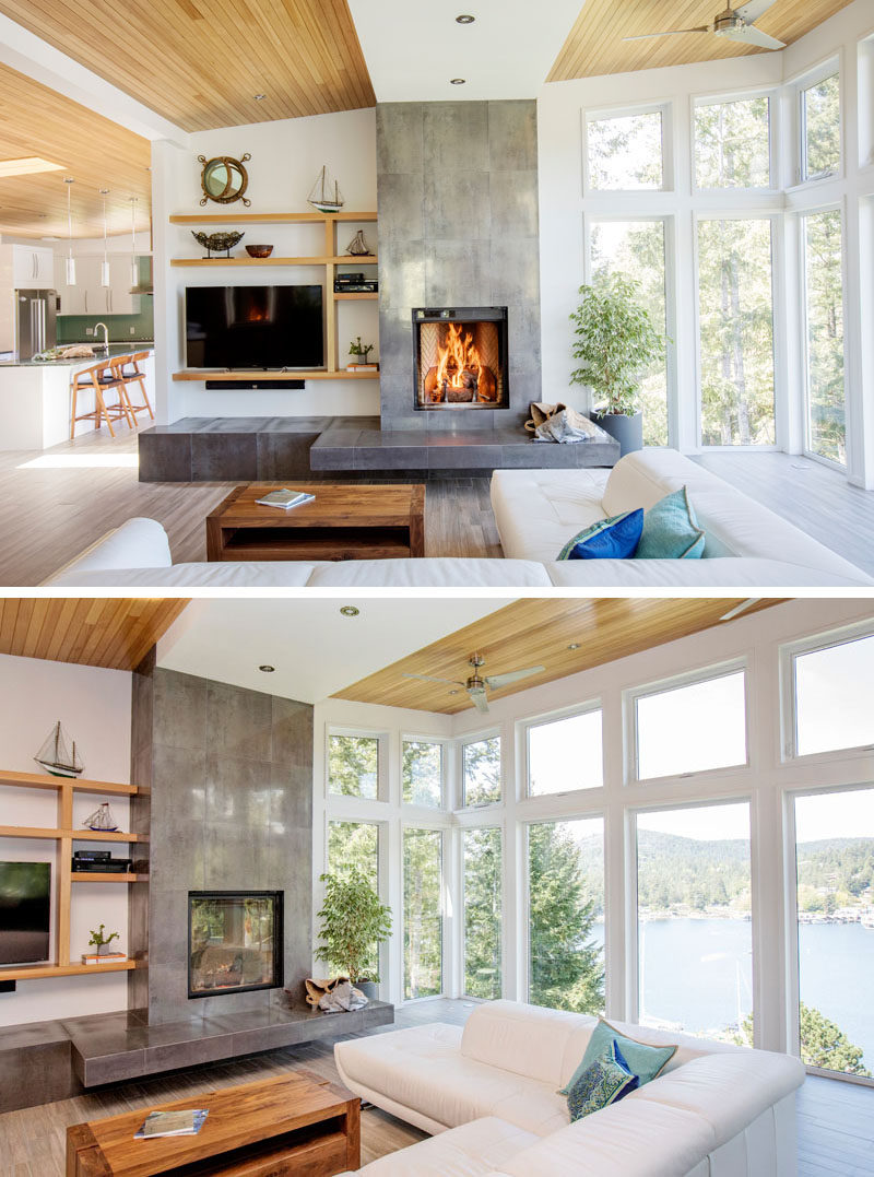 In this modern living room, the fireplace is the focal point, while large windows provide ample natural light and a view of the water. #LivingRoom #Fireplace #Windows