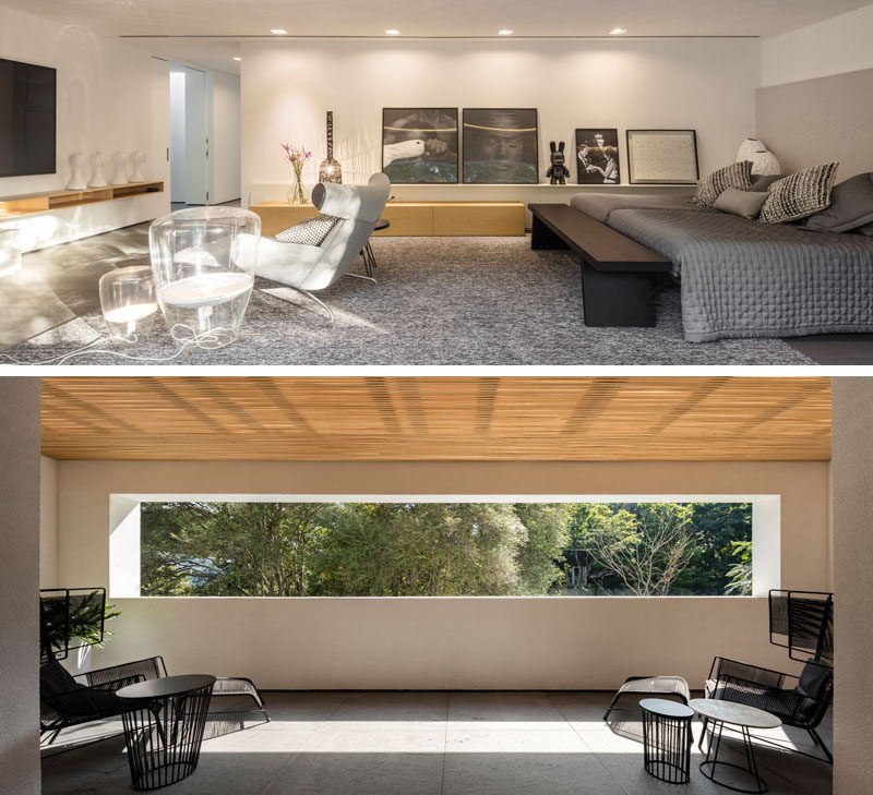 This large and modern master bedroom has a sitting area for watching TV, a picture rail that lines the wall and displays artwork, and a private covered balcony. #ModernMasterBedroom #BedroomDesign #CoveredBalcony