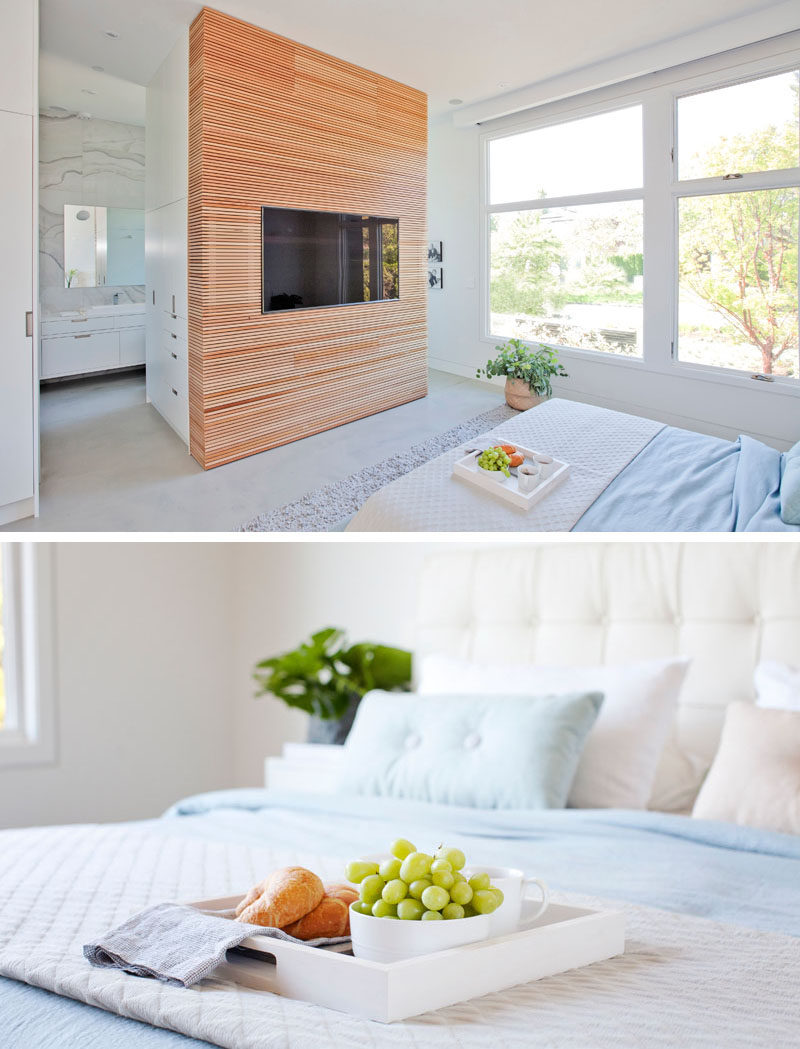 This modern master suite has a wood accent wall that surrounds the television. #WoodAccentWall #BedroomDesign