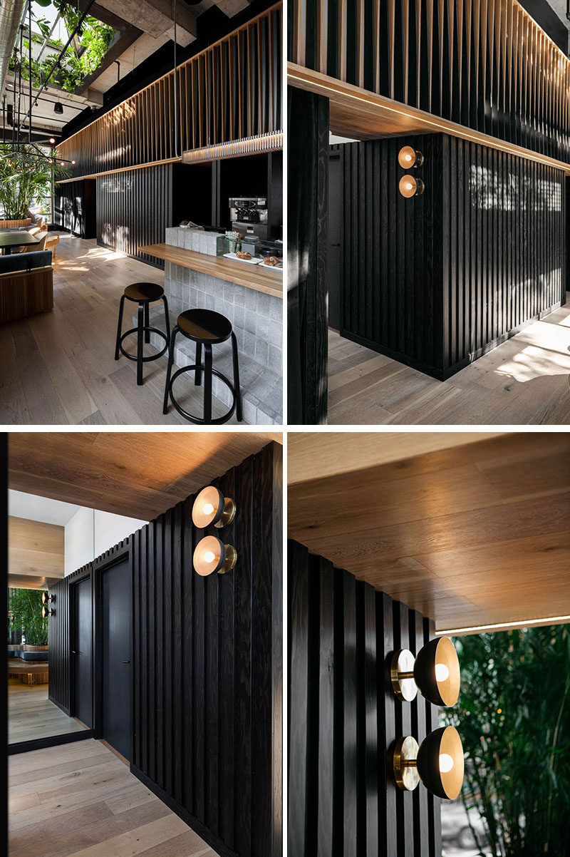 Along the back wall of this modern restaurant, dark and light wood slats create an optical effect that gives movement as you pass through the space. #RestaurantDesign #ModernRestaurant #WoodSlats